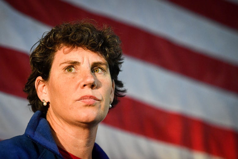 Amy McGrath stands in front of an American flag.